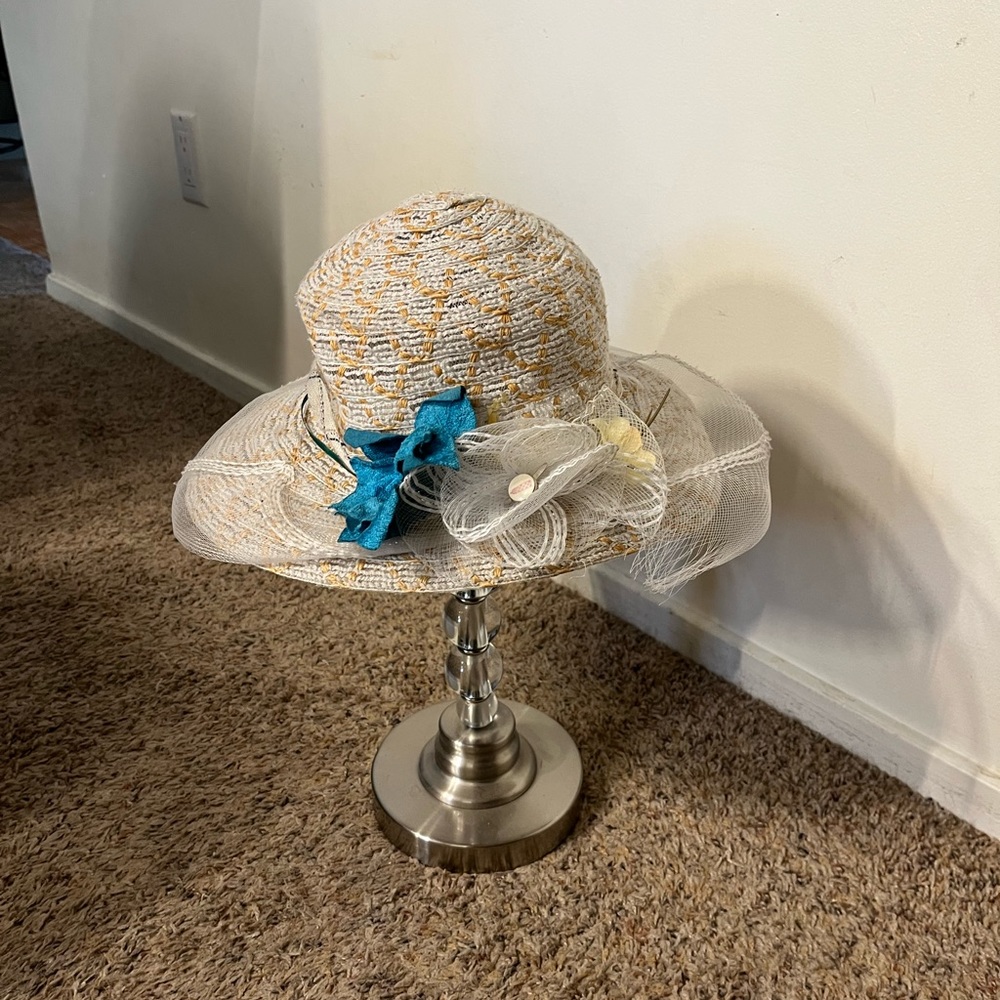 Vintage ladies hat of unknown origin. It has a brim that curves down. GUC.